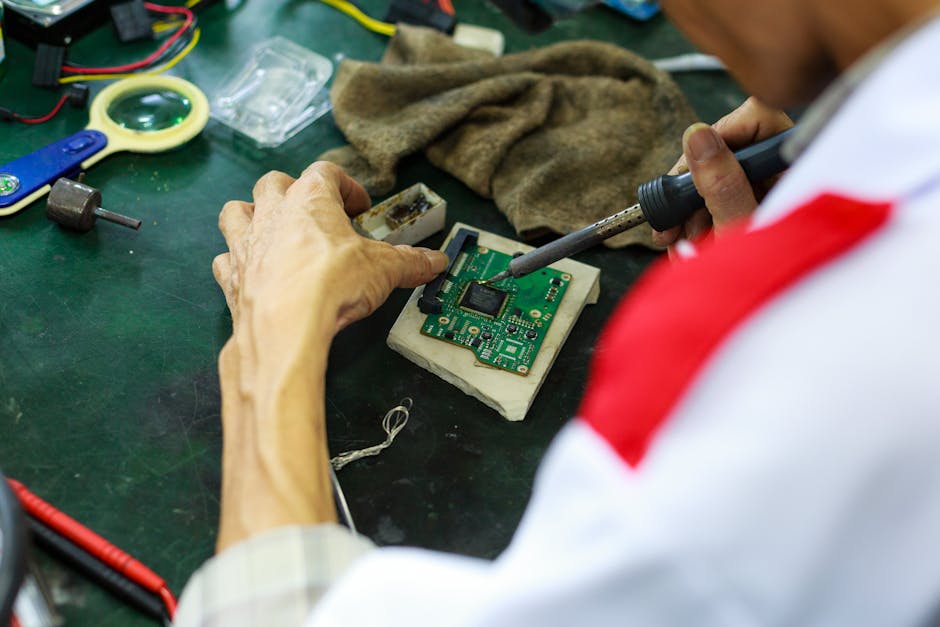 A skilled technician uses a soldering iron to repair and solder a circuit board.