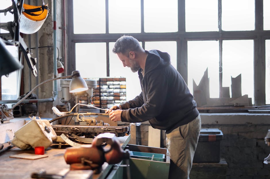 Experienced craftsman skillfully repairing equipment in a spacious and light-filled workshop.